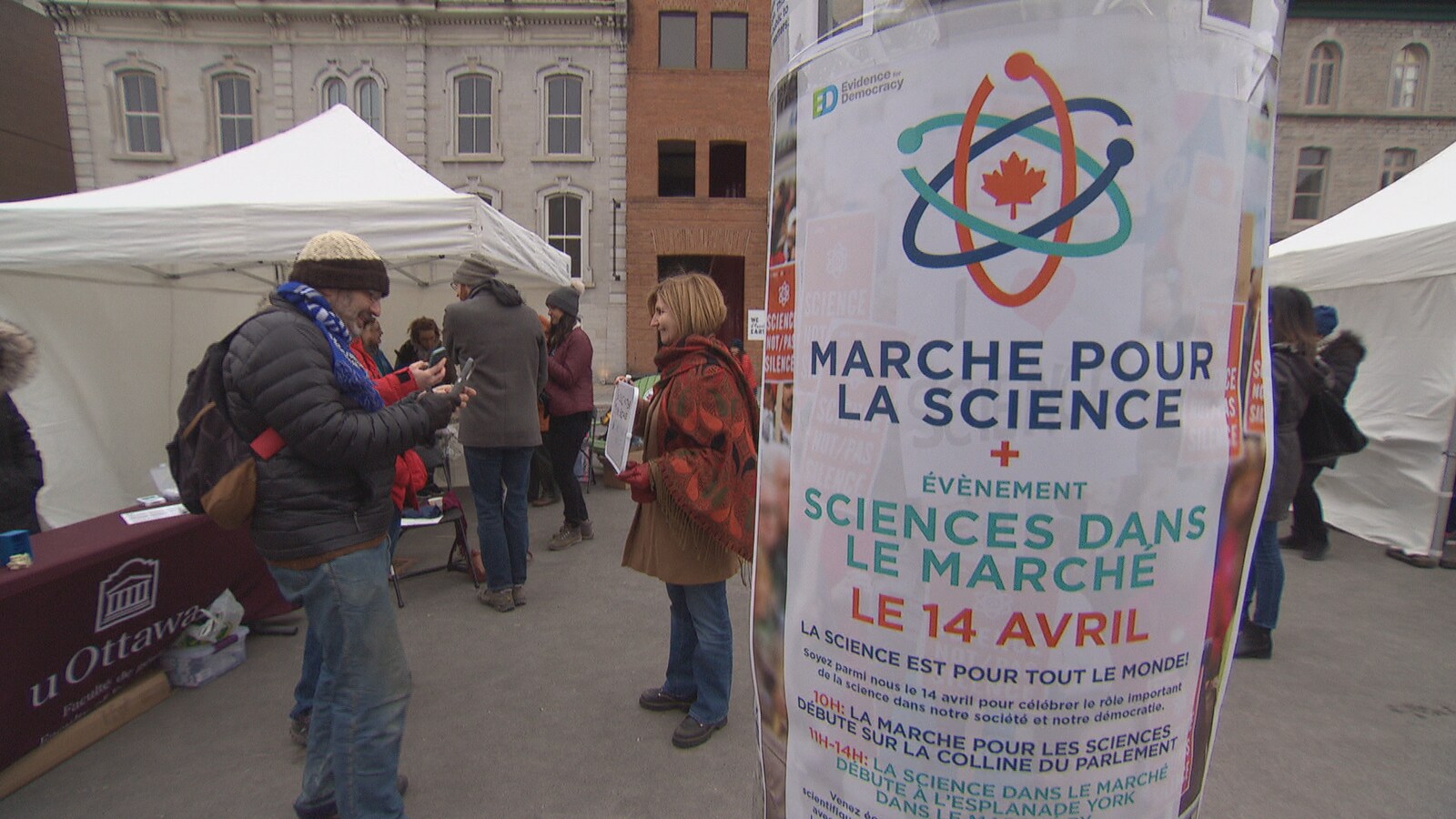 Une affiche de la Marche pour la science sur un poteau, dans une rue passante