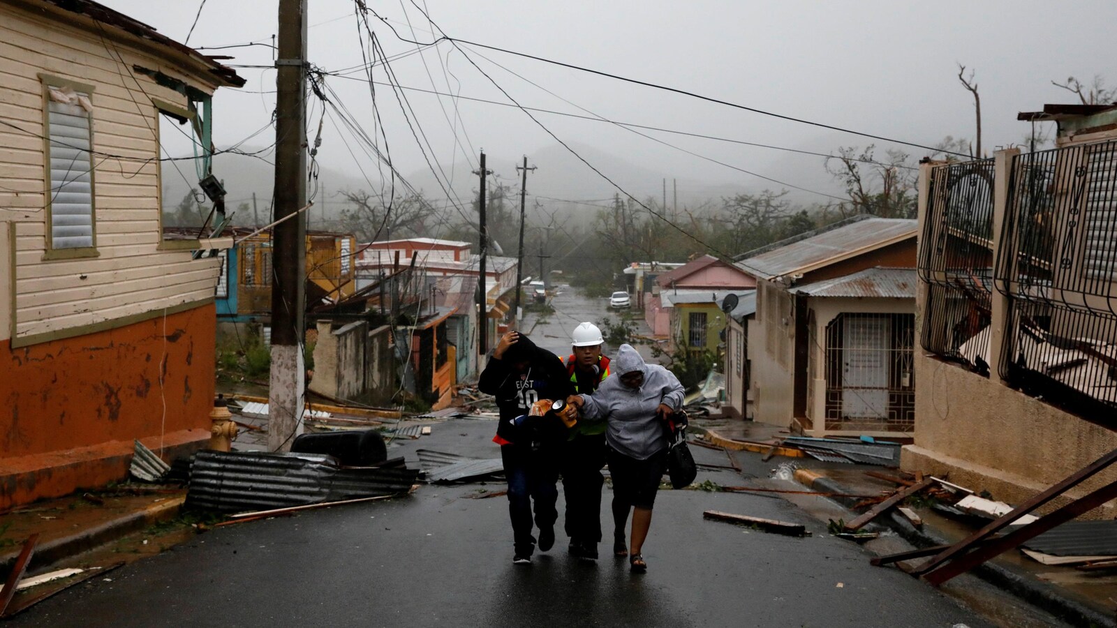 Un secouriste aide deux personnes après le passage de l'ouragan Maria à Guayama, à Porto Rico.