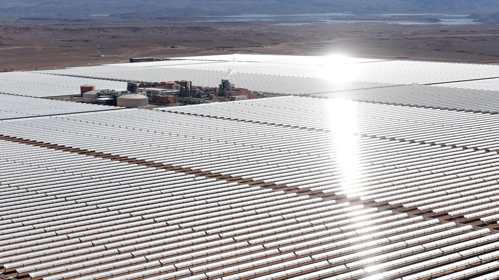 Des centaines de panneaux solaires sont installés autour de petites installations industrielles.