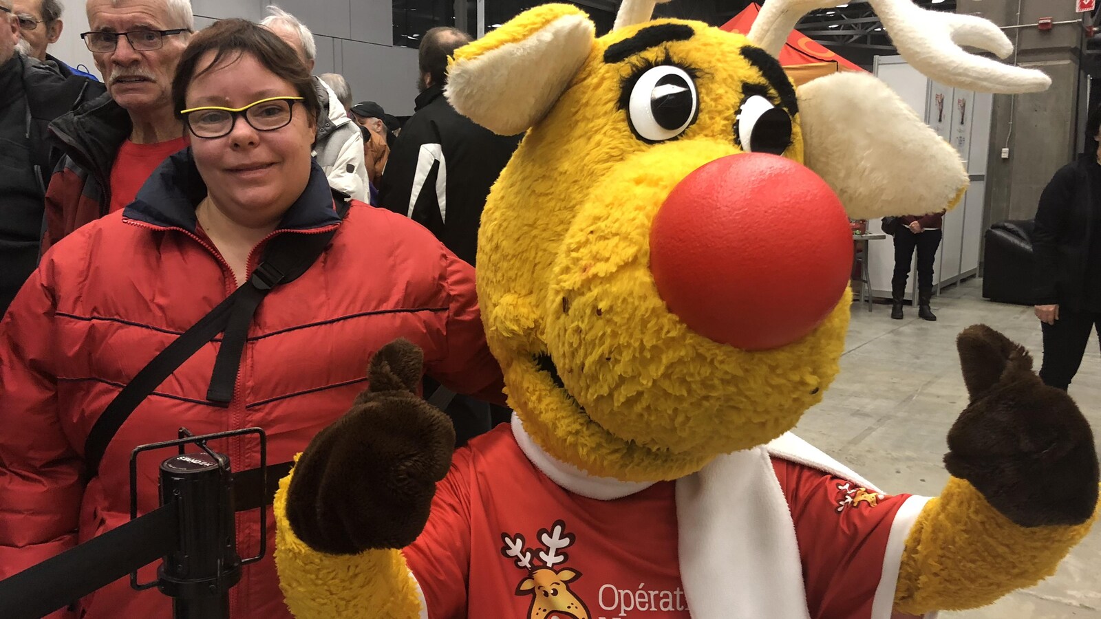 La mascotte d'Opération Nez rouge accompagnée d'une bénévole.