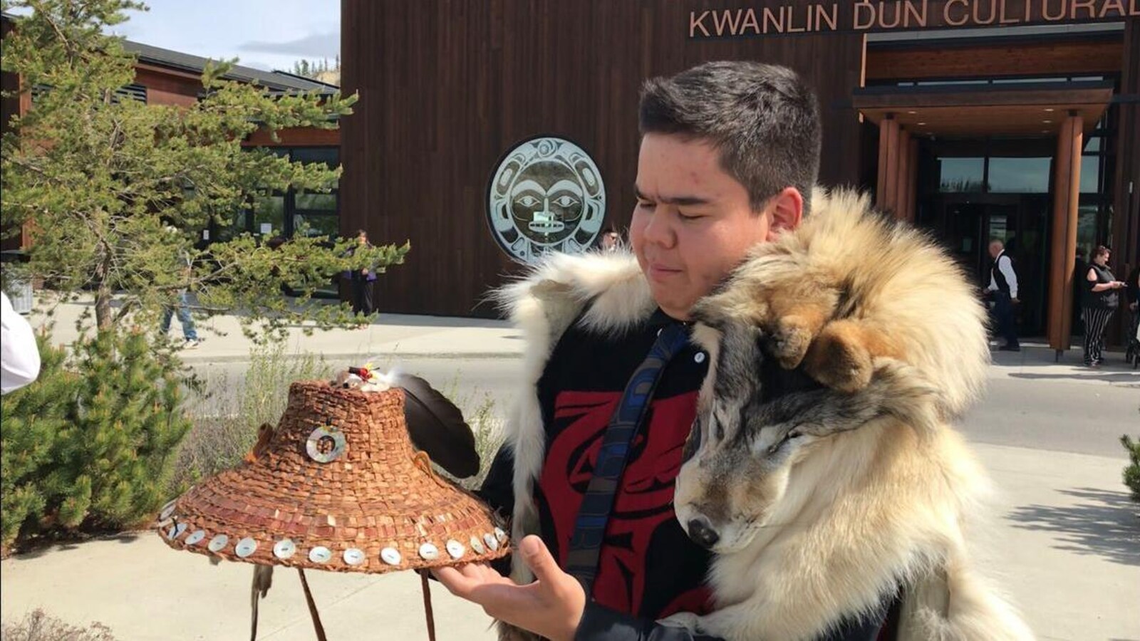 Matthew Wesley qui a sur ses épaules une fourrure de loup regarde avec attention son chapeau en cèdre dans ses mains.