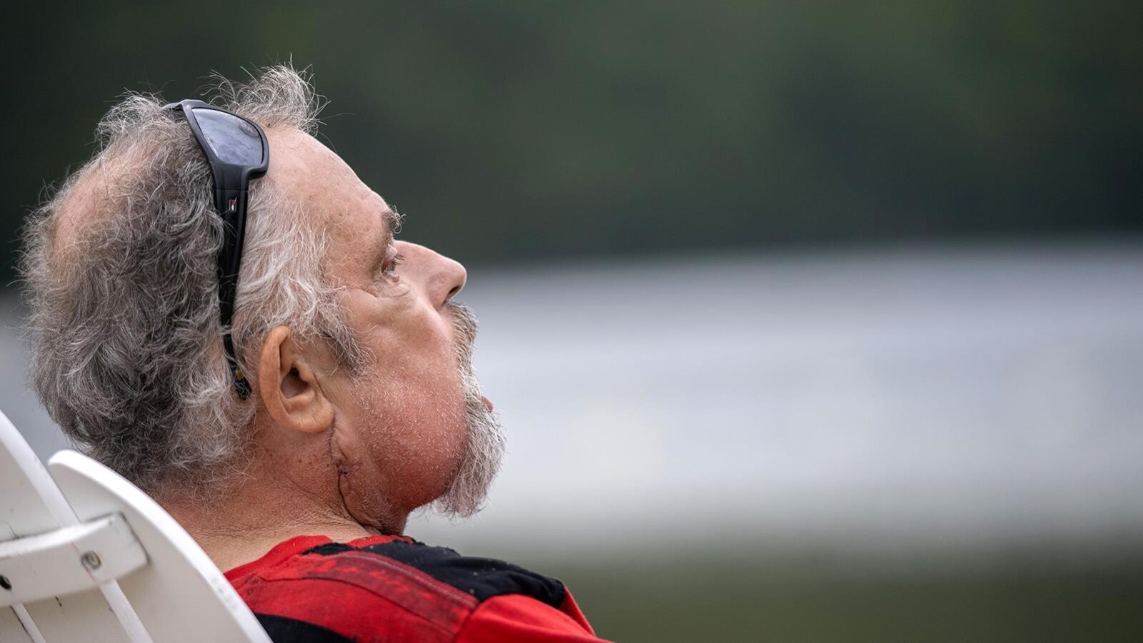 Maurice de profil, assis sur une chaise et regardant au loin