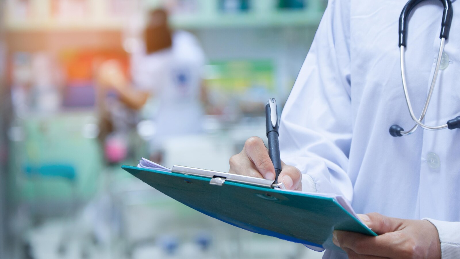 Un médecin écrit sur un bloc de papier.