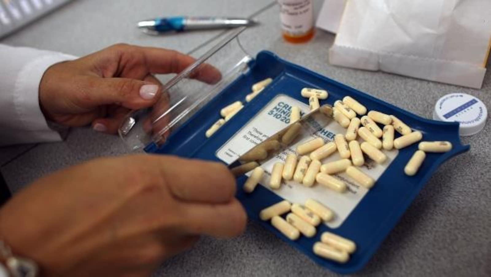 Des mains de pharmaciens trient des pilules