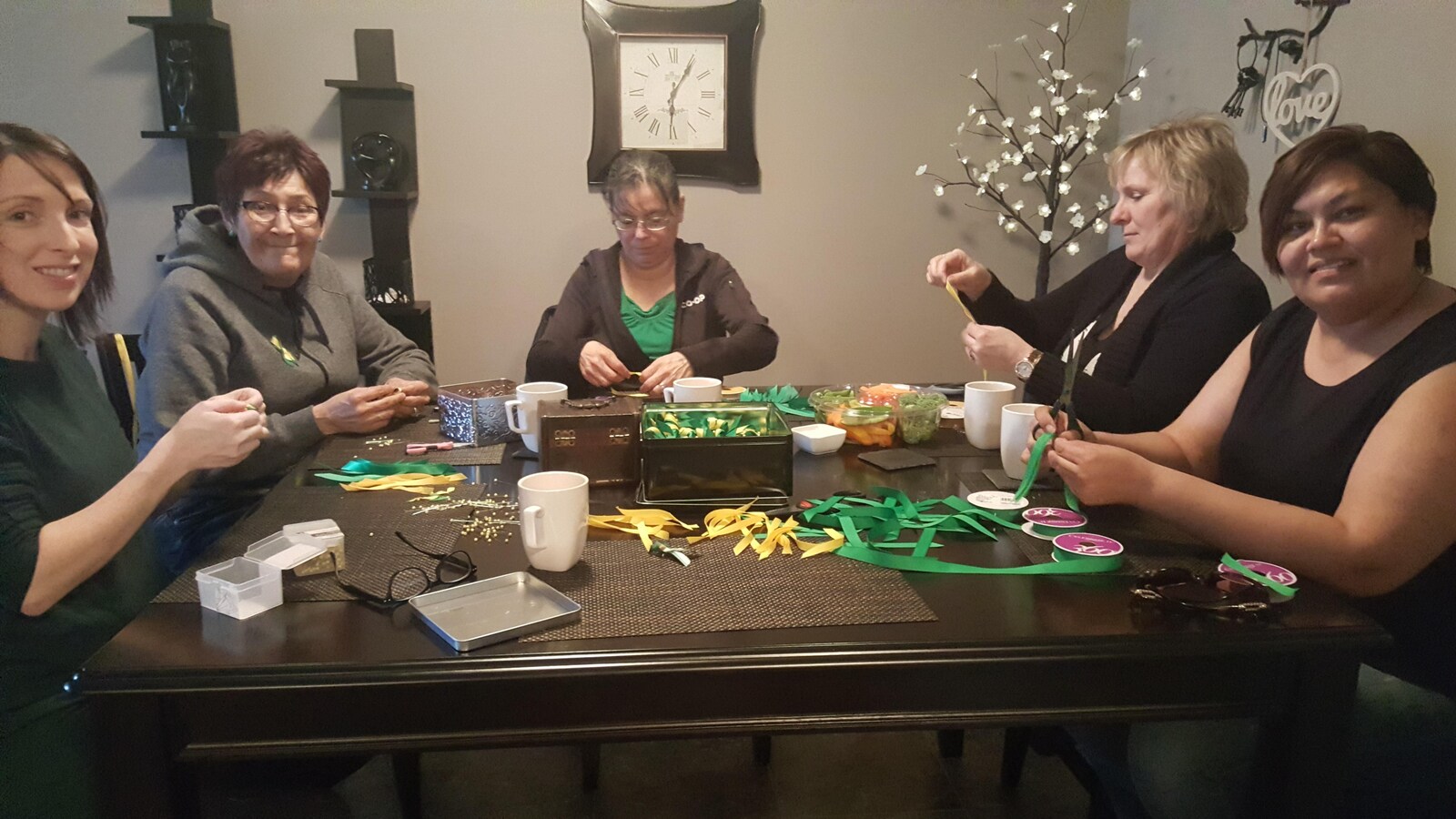 Des mères de familles de La Ronge, autour d'une table, confectionnent des rubans.