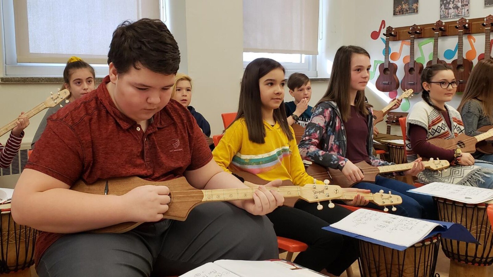 Des enfants jouent de cette petite guitare.