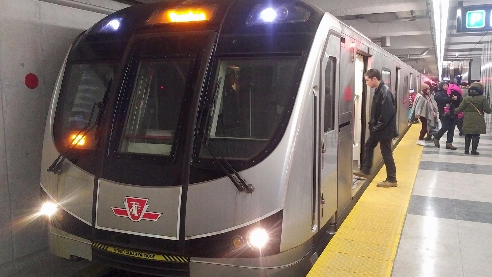 Des usagers montent à bord d'une rame de métro.
