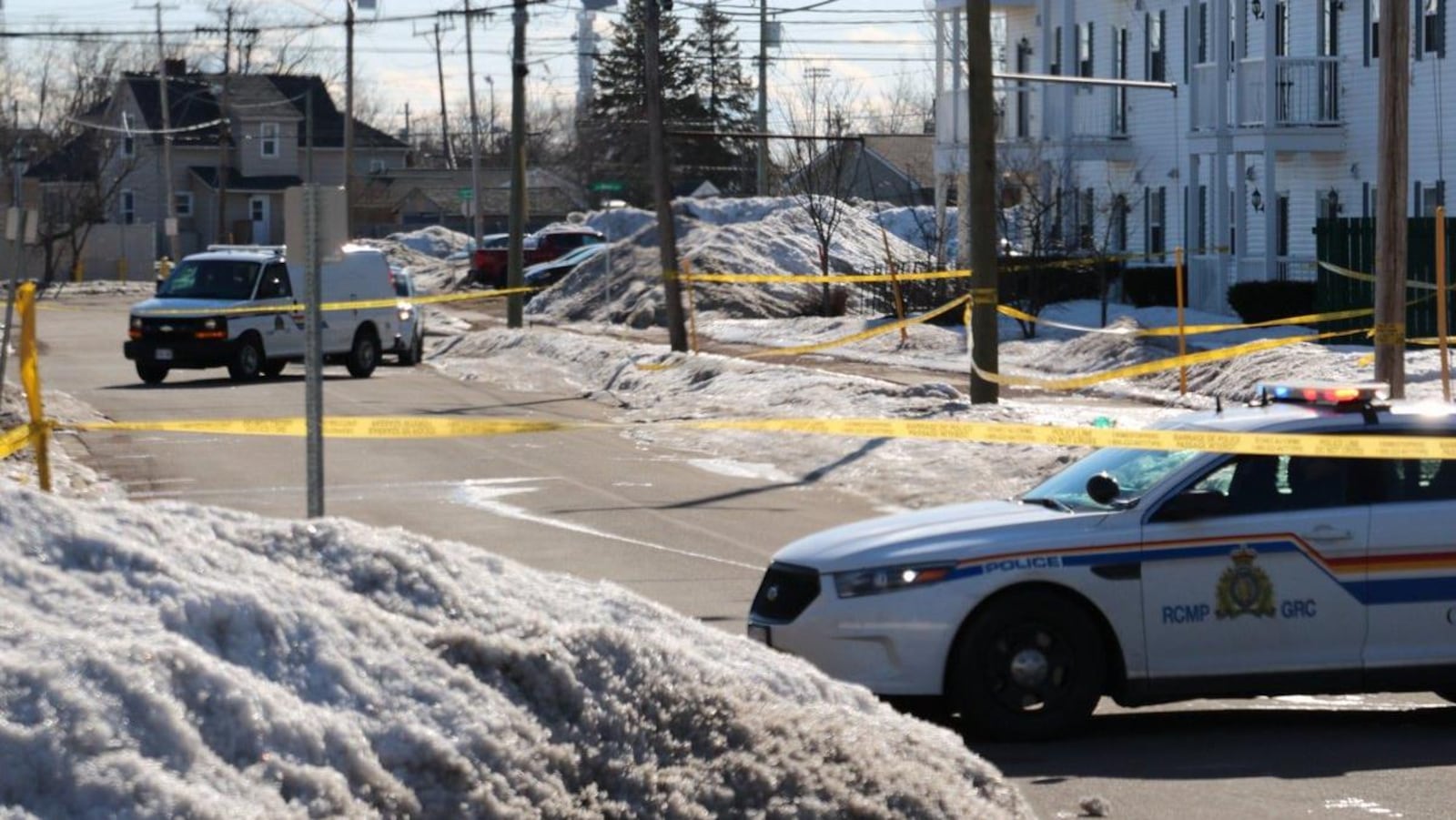 Des véhicules de police encerclent la scène de crime.