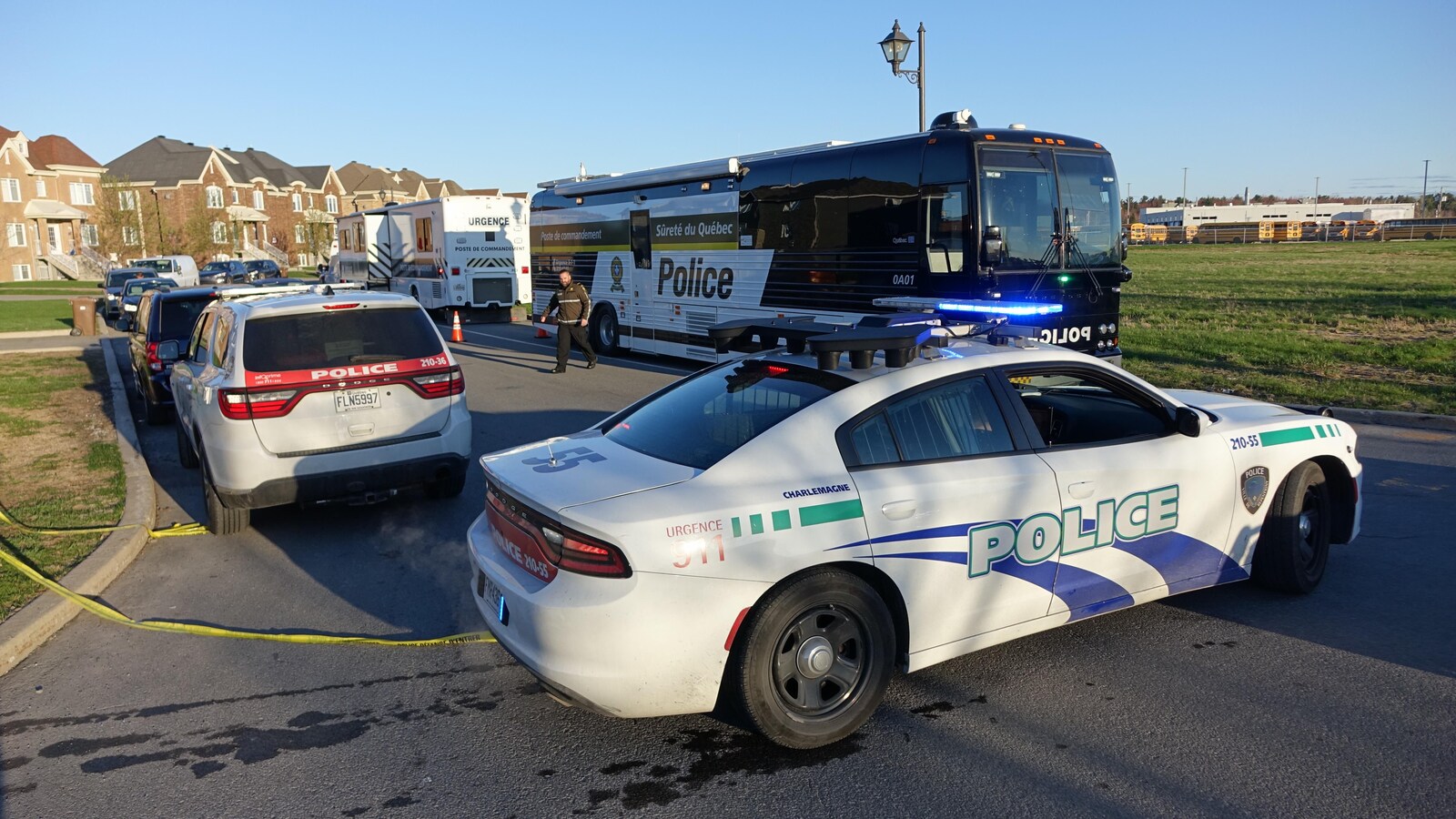 Des véhicules policiers sont stationnés dans un quartier résidentiel.