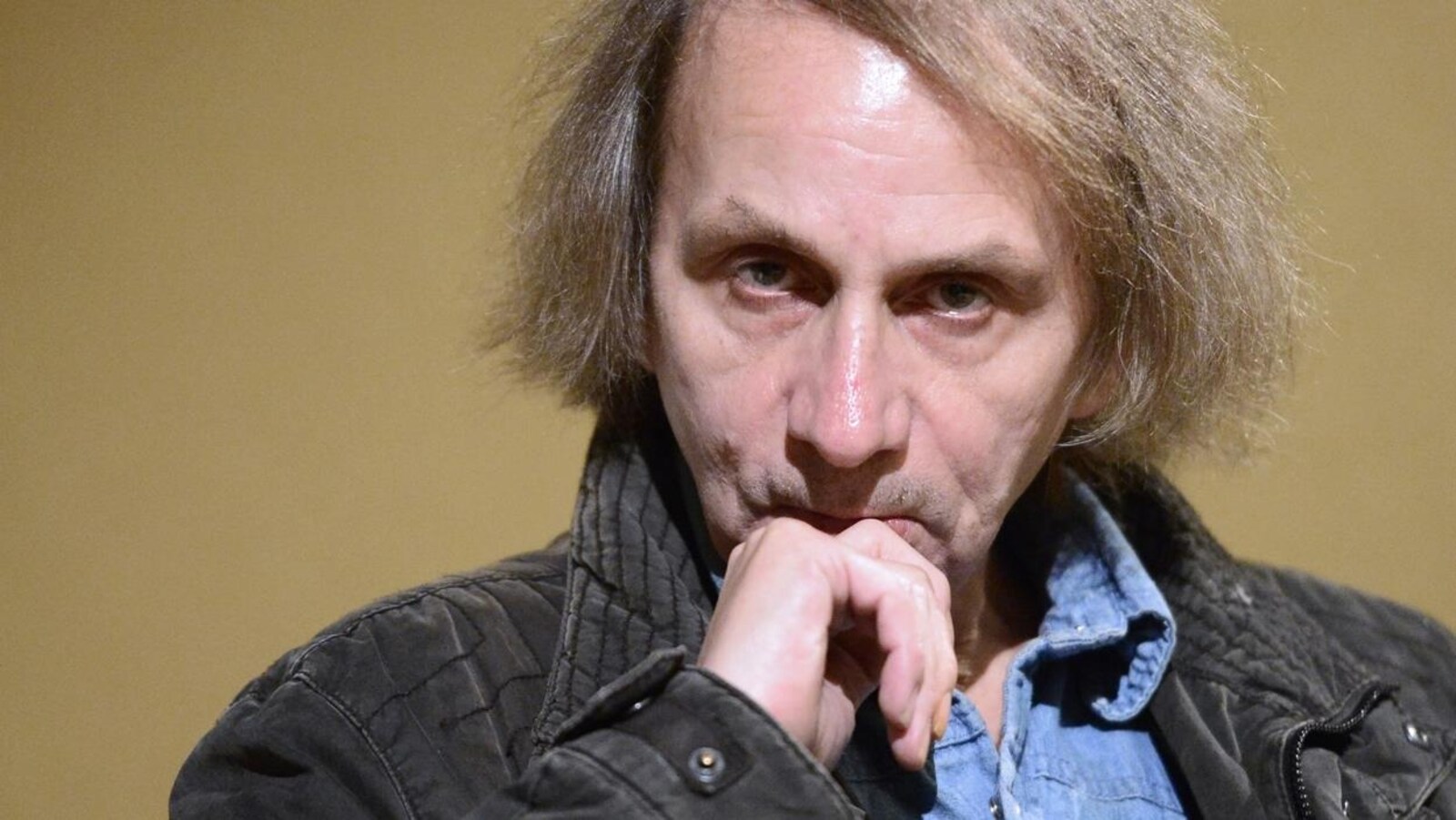 L'écrivain regarde la caméra de manière fixe.