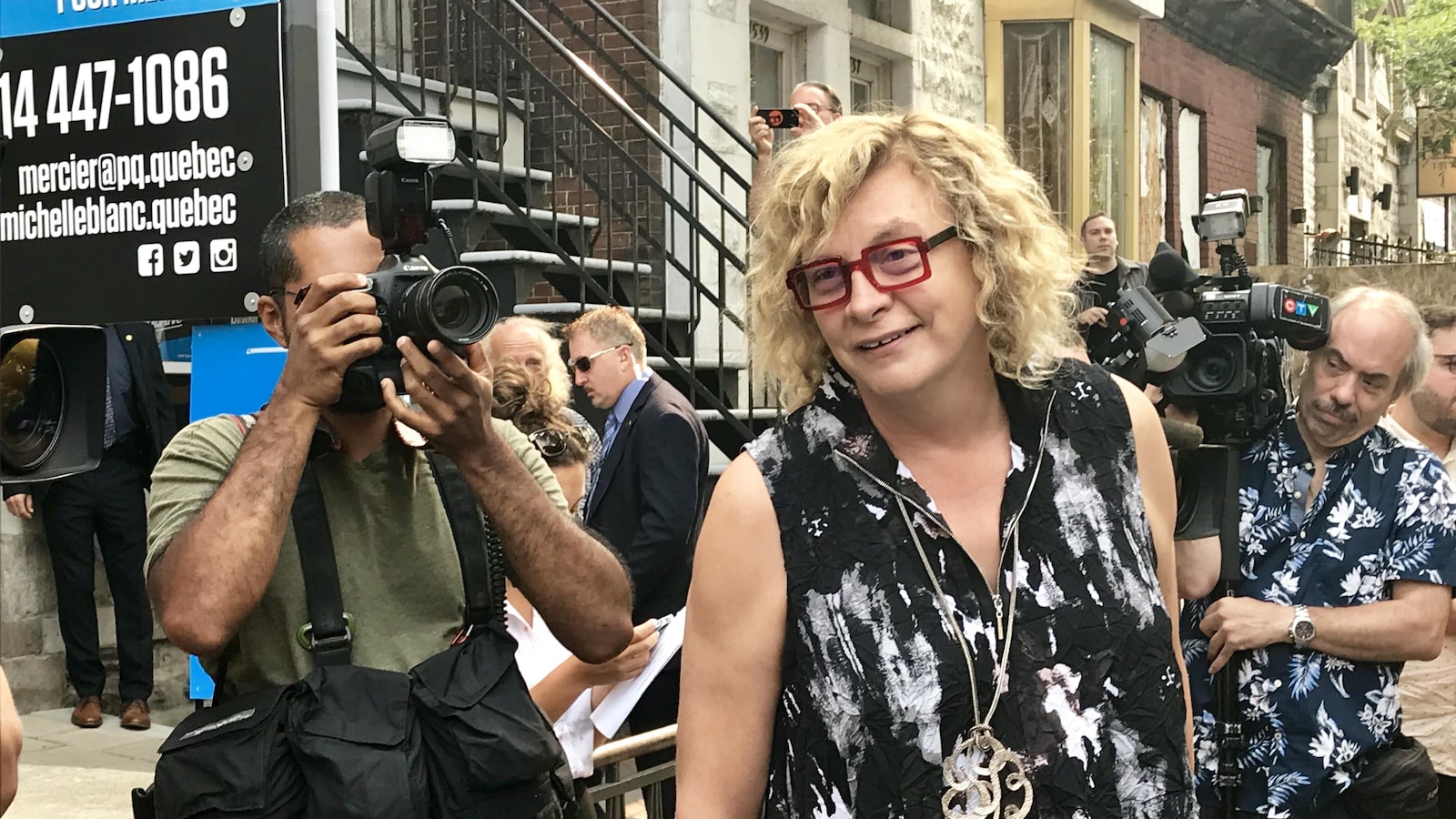 Michelle Blanc, entourée de photographes.
