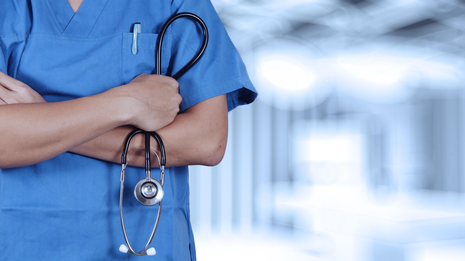 Photo générique d'un travailleur de la santé, les bras croisés, avec un stéthoscope en main.