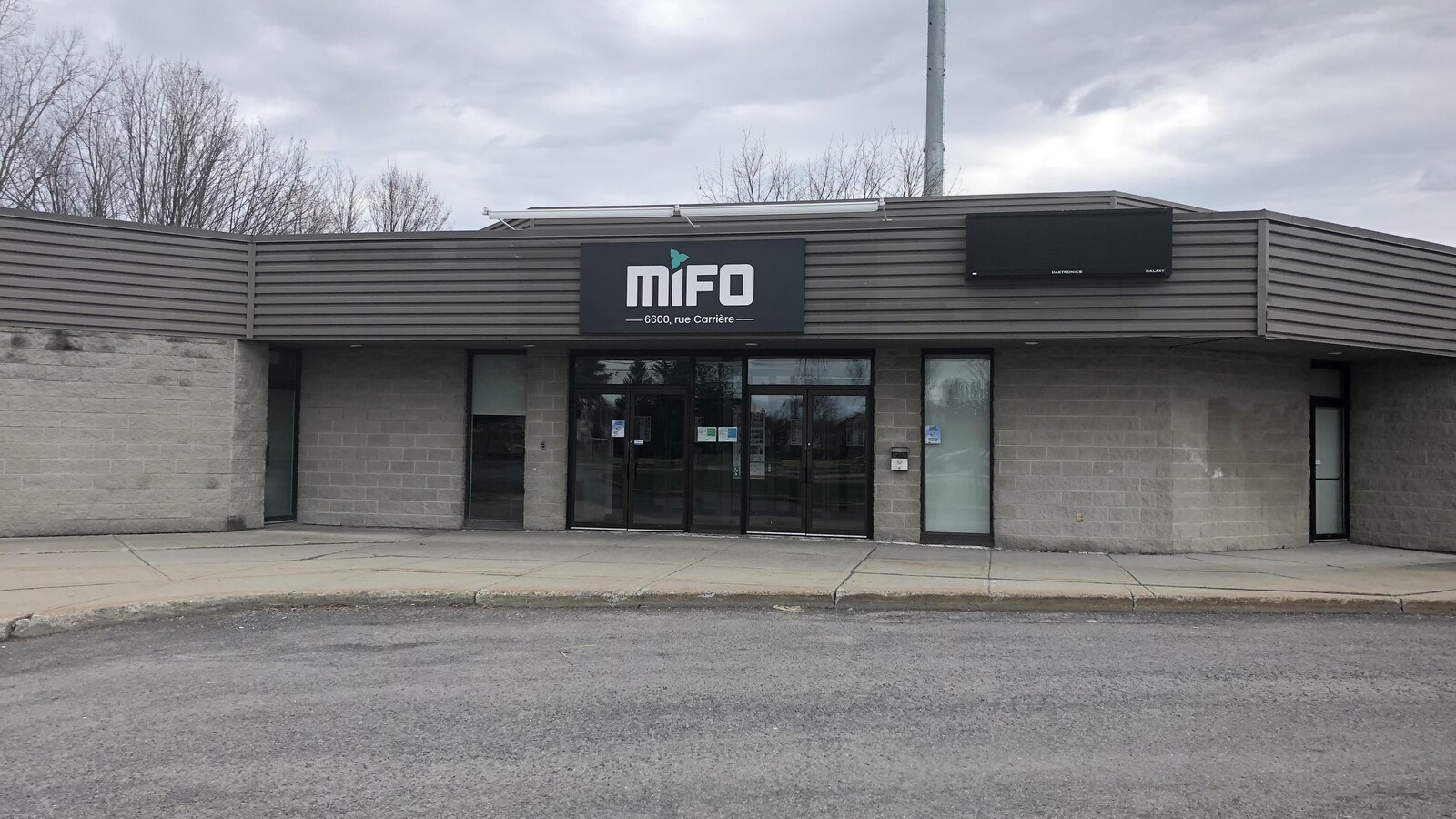 Un édifice gris avec une affiche du MIFO