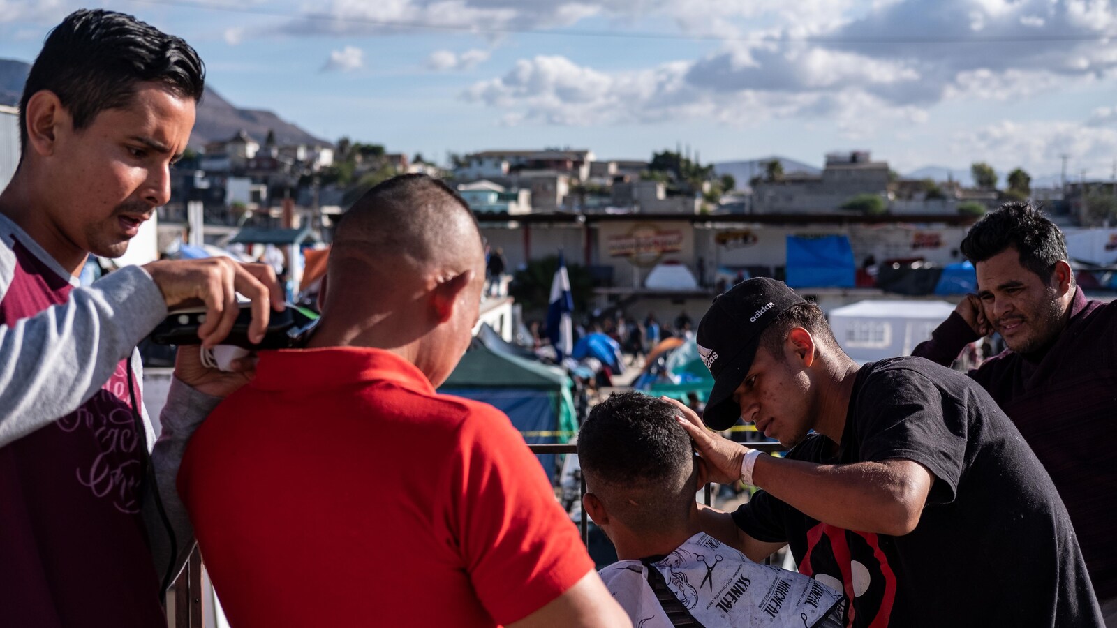 Des migrants honduriens se font couper les cheveux.
