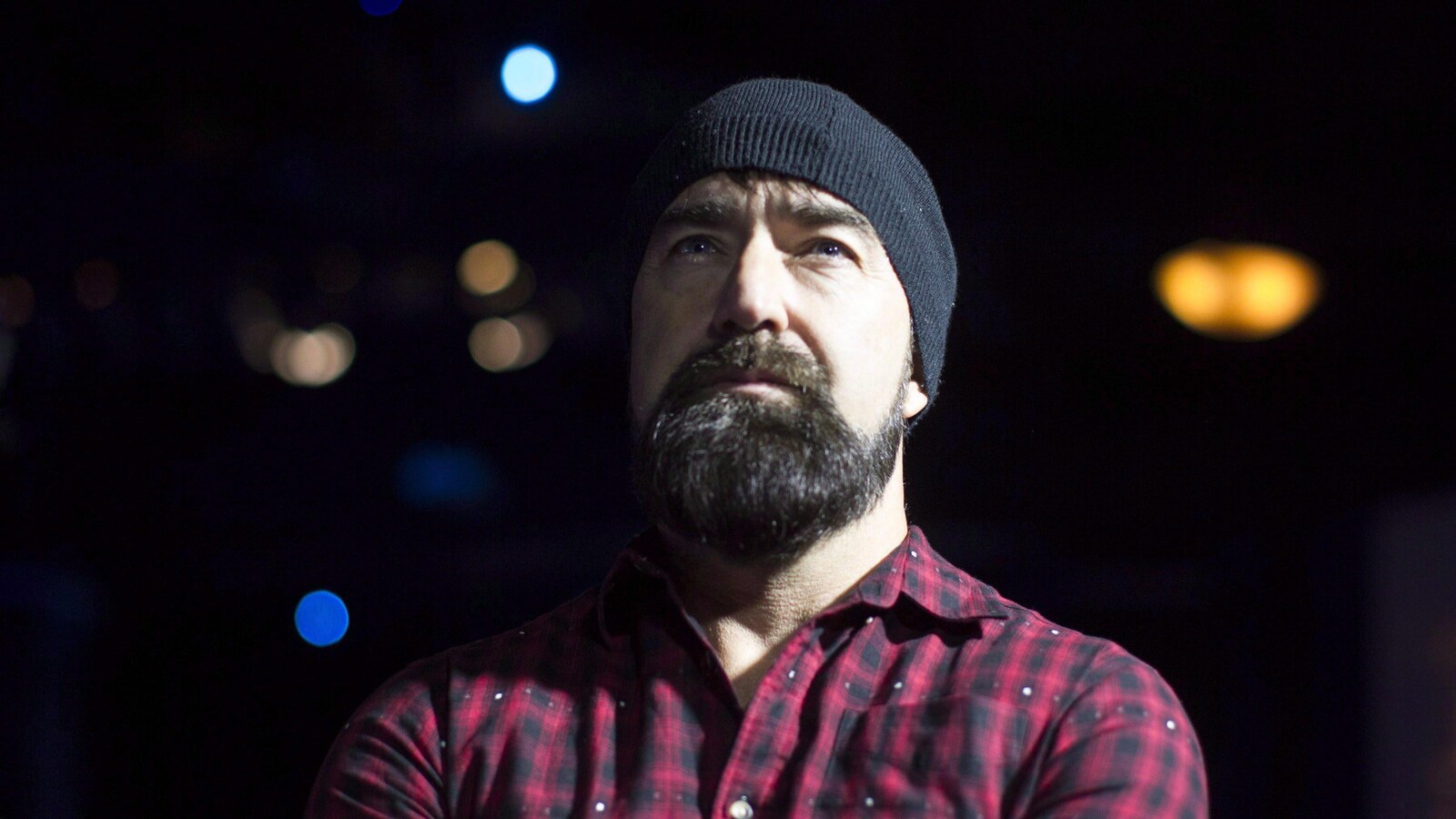 Le musicien Mike Taylor portant une tuque et une chemise carreautée.