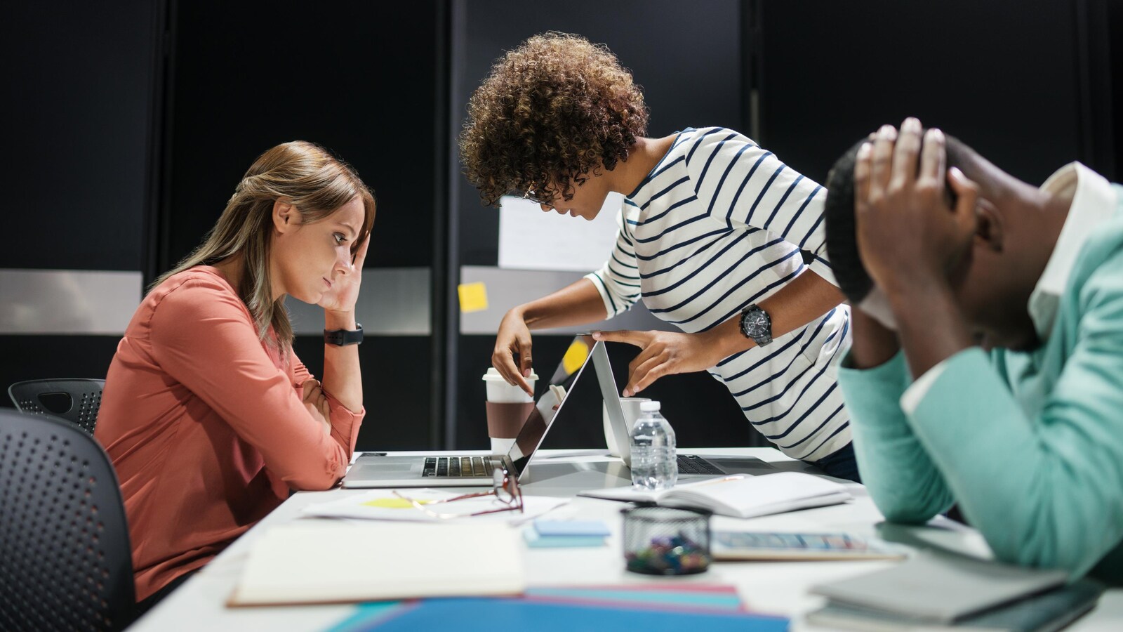 Groupe de jeunes travailleurs fatigués autour d'un ordinateur.
