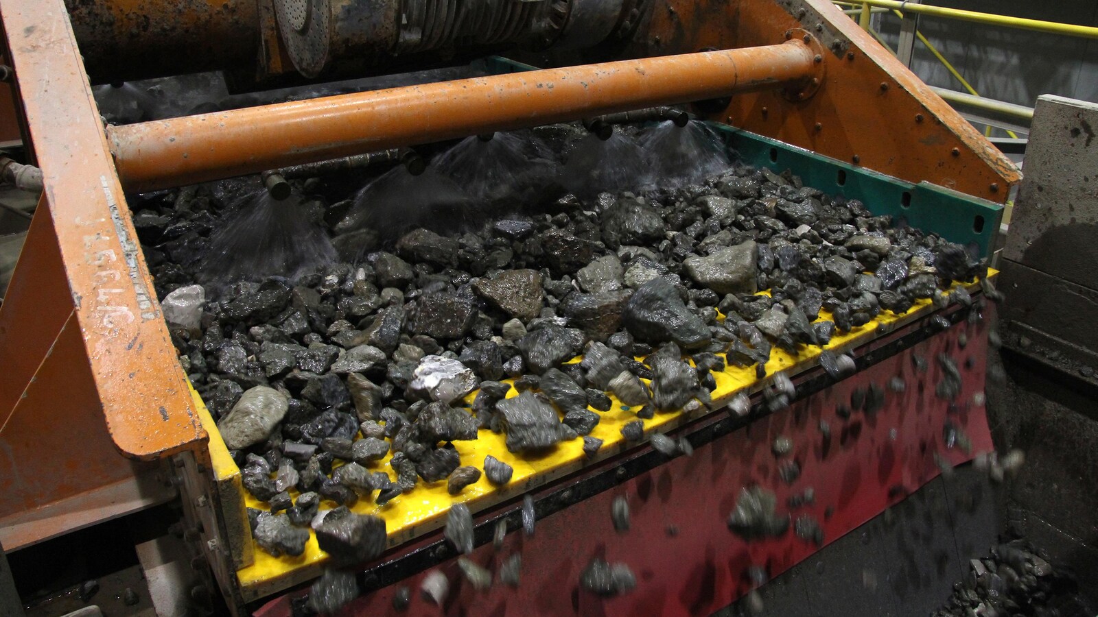 Des roches scintillantes sont aspergées par une machine.