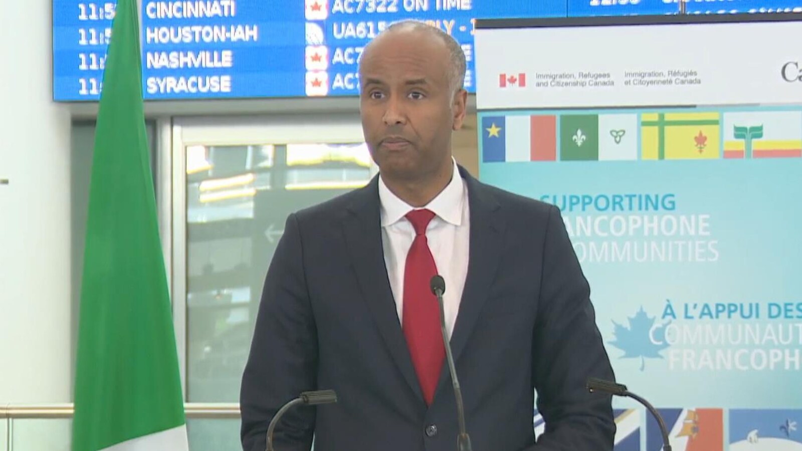 Ahmed Hussen portant un complet devant un micro.