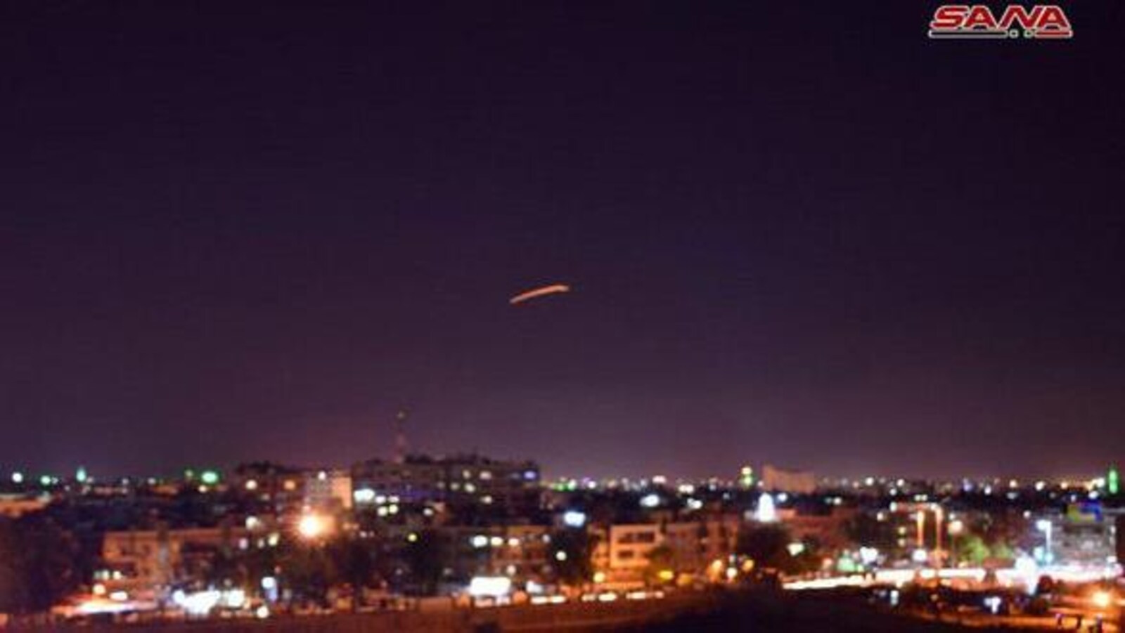 Damas est éclairée par les lumières de la ville. En pleine nuit, un tir de missile est visible dans le ciel, au loin.