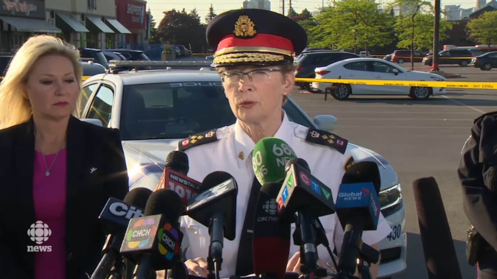 Une femme portant une casquette et un uniforme de police devant des microphones