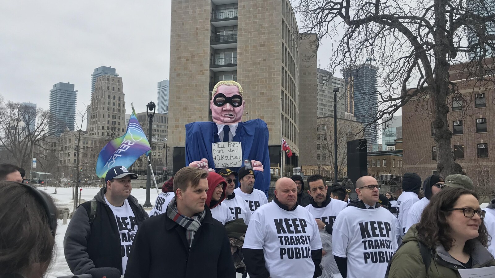 Des manifestants arborant des chandails avec l'inscription « Gardez notre système de transport en commun public ».