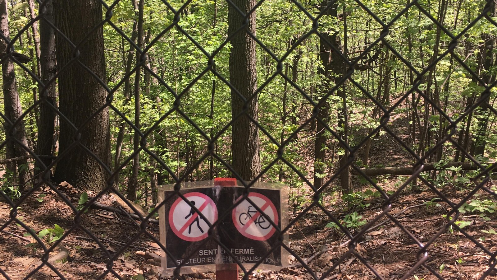 Une clôture et une pancarte interdisant l'accès à pied et à vélo.
