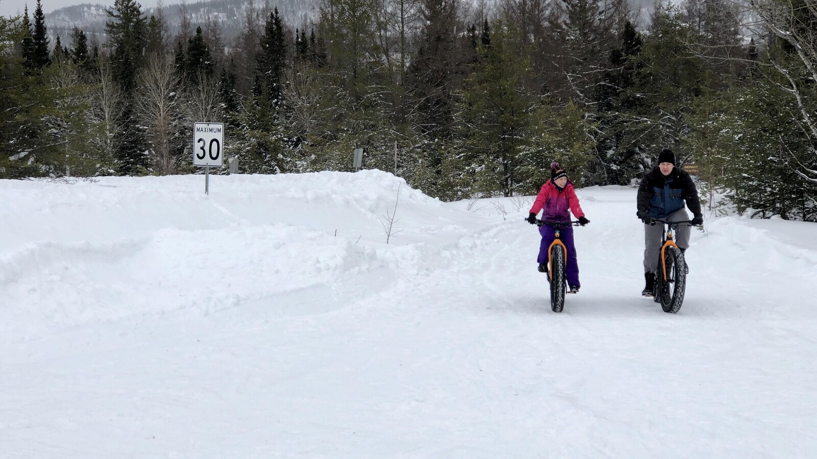 Deux citoyens circulent en vélo à neige au Parc nationale des Monts-Valin.