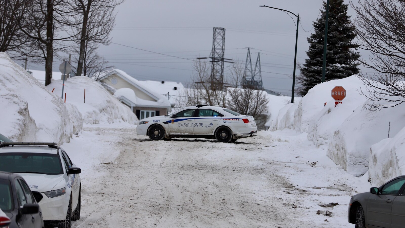 Une voiture de police est stationnée en travers d’une rue dans un quartier résidentiel de Val-Bélair.