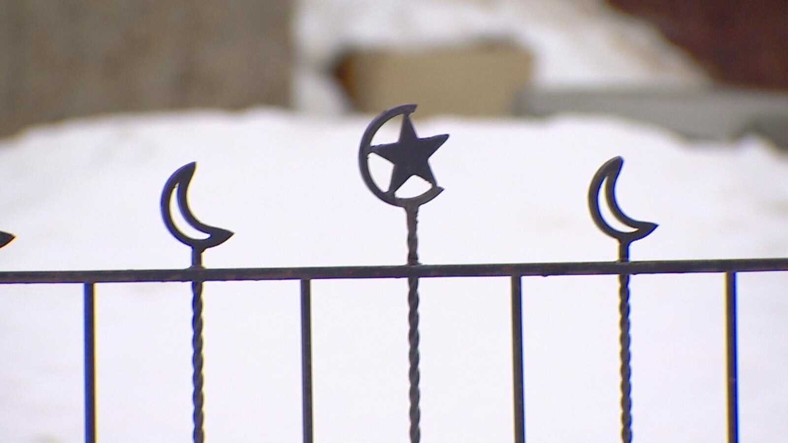 Gros plan sur une barrière de fer forgée surmontée du croissant et de l'étoile musulman.s