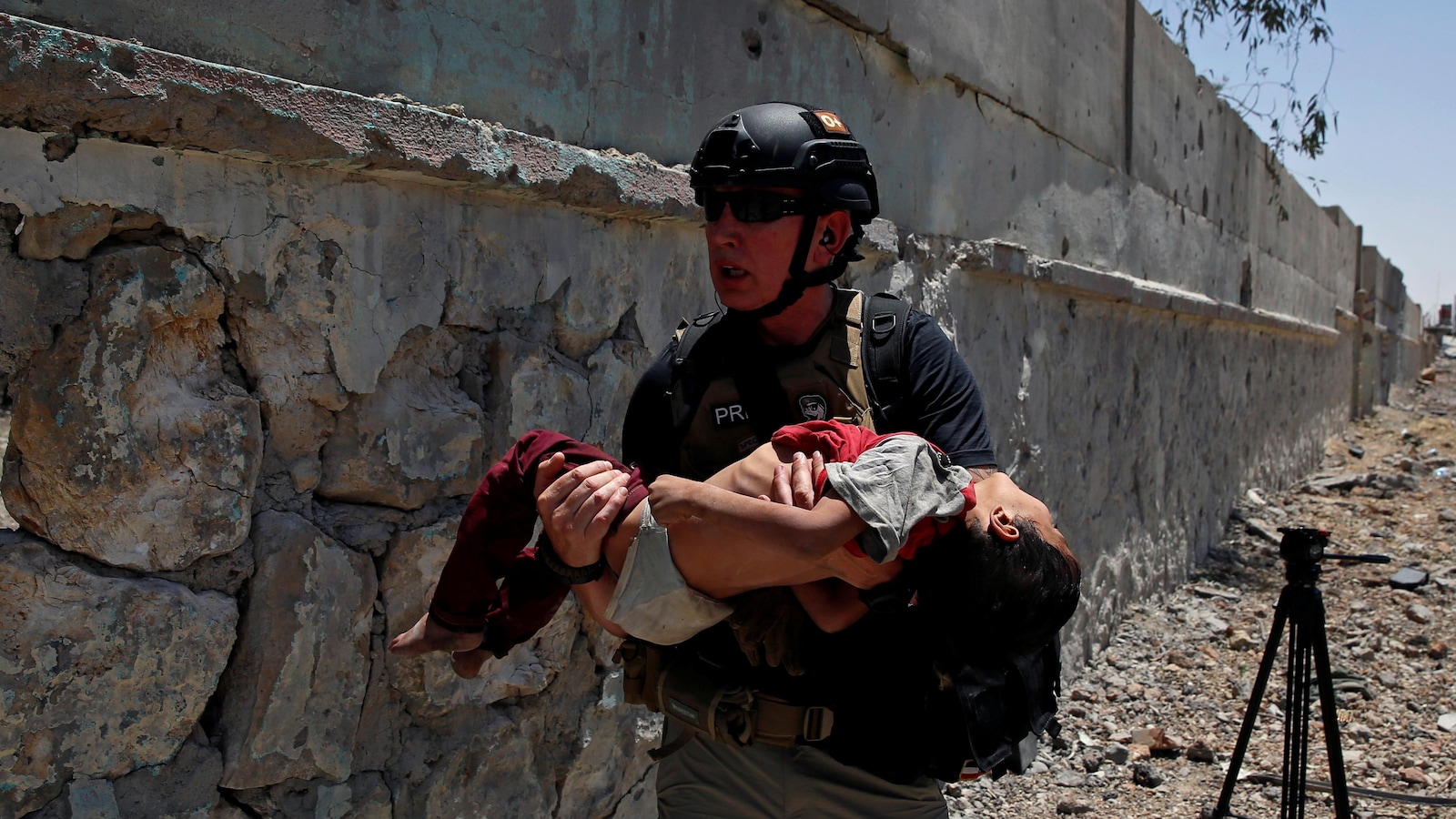 Un membre de la presse transporte un enfant gravement déshydraté dans un quartier de Mossoul.