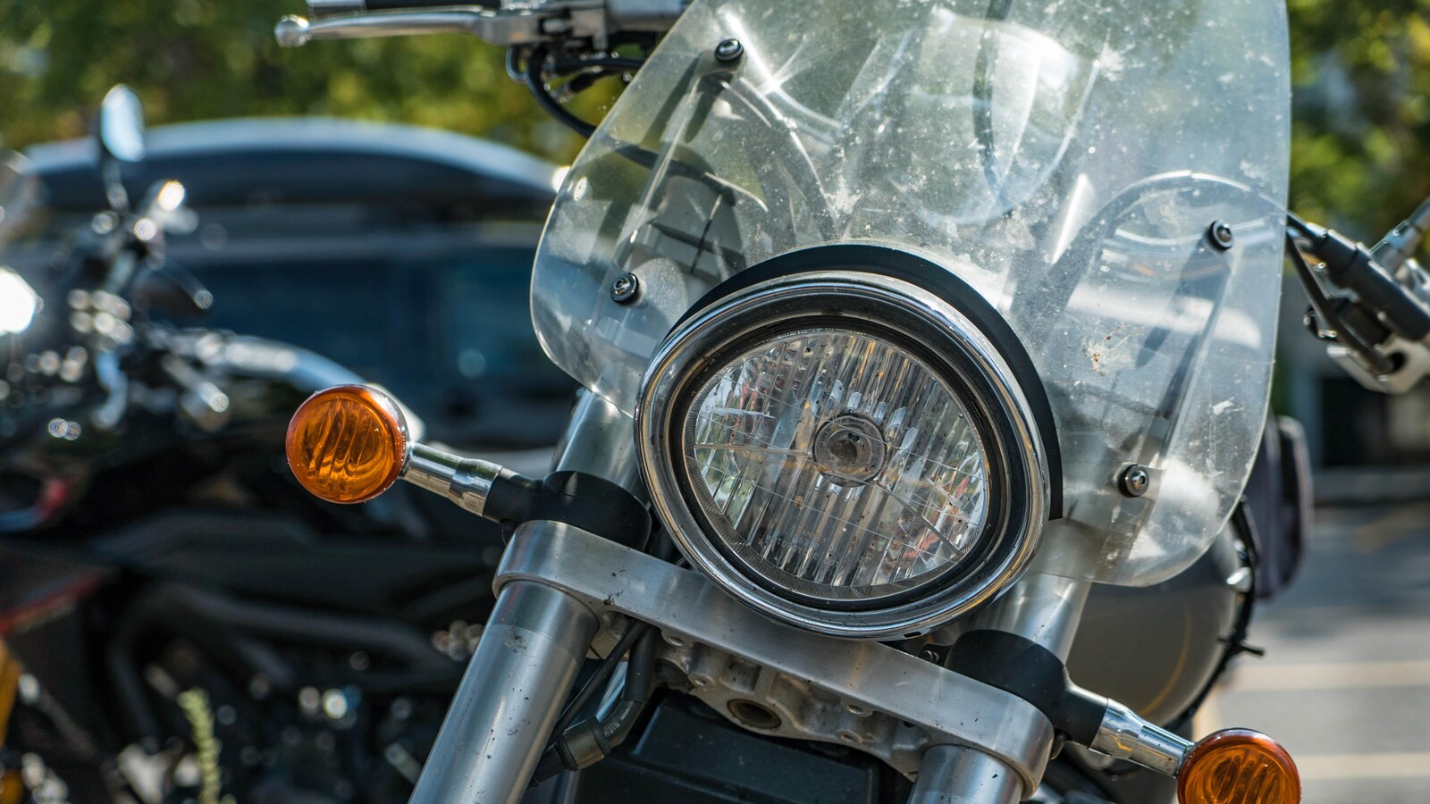 Une motocyclette noire et argentée qui est stationnée.