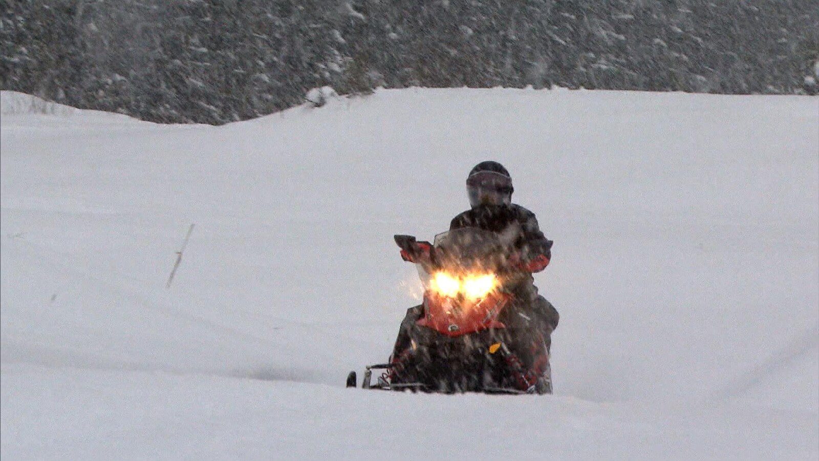 Un motoneigiste circulant dans des conditions de neige abondante