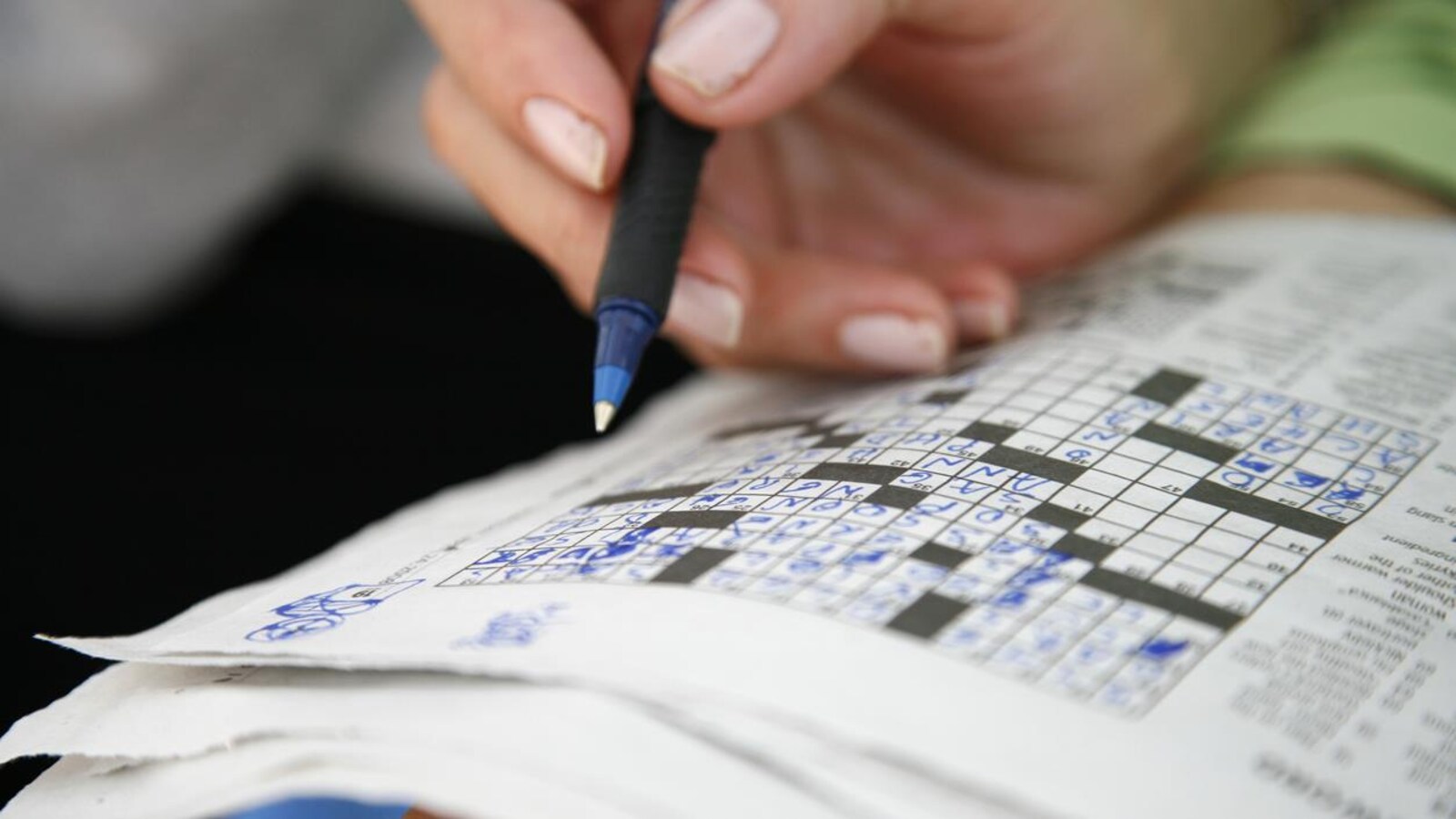 Une personne fait des mots croisés.