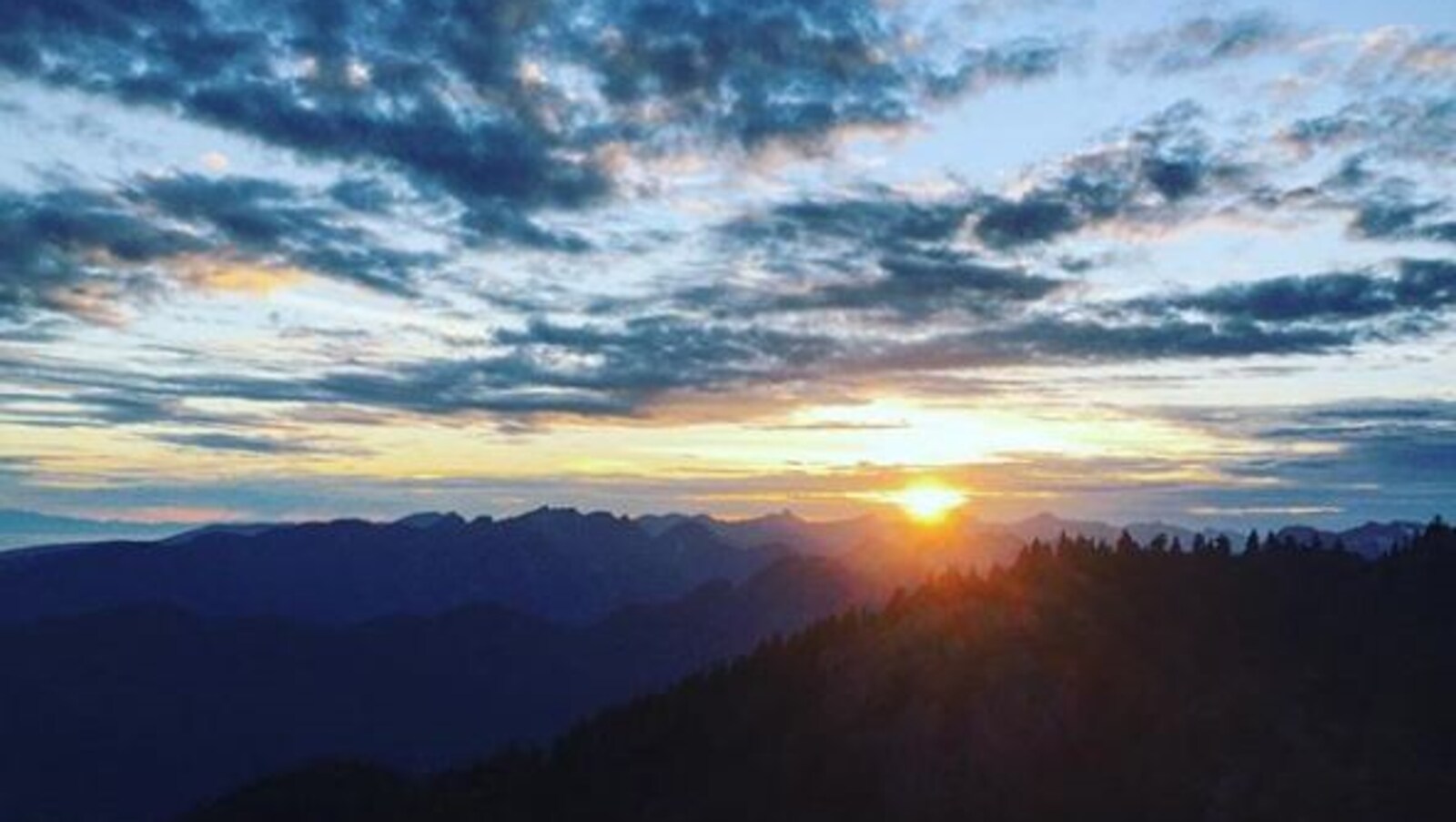 Une vue du soleil couchant dans les montagnes.