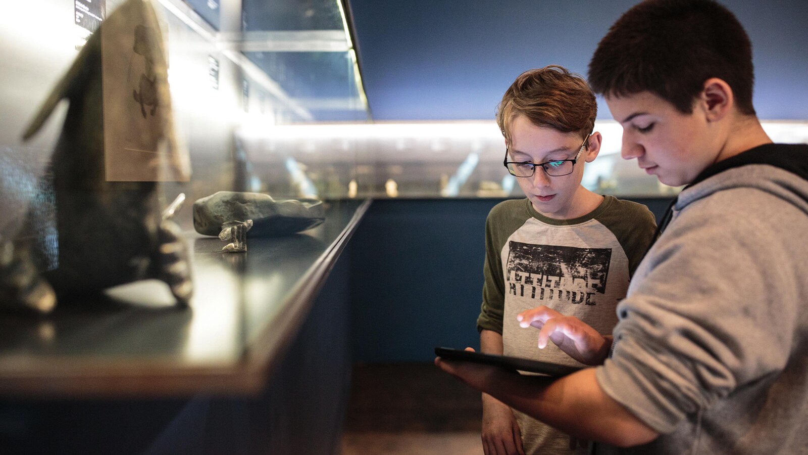 Deux élèves consultent une tablette informatique dans un musée