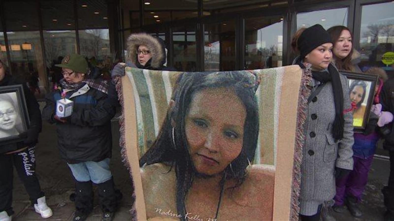 Des proches de Nadine Machiskinic tiennent un portrait de la femme dans leurs mains.