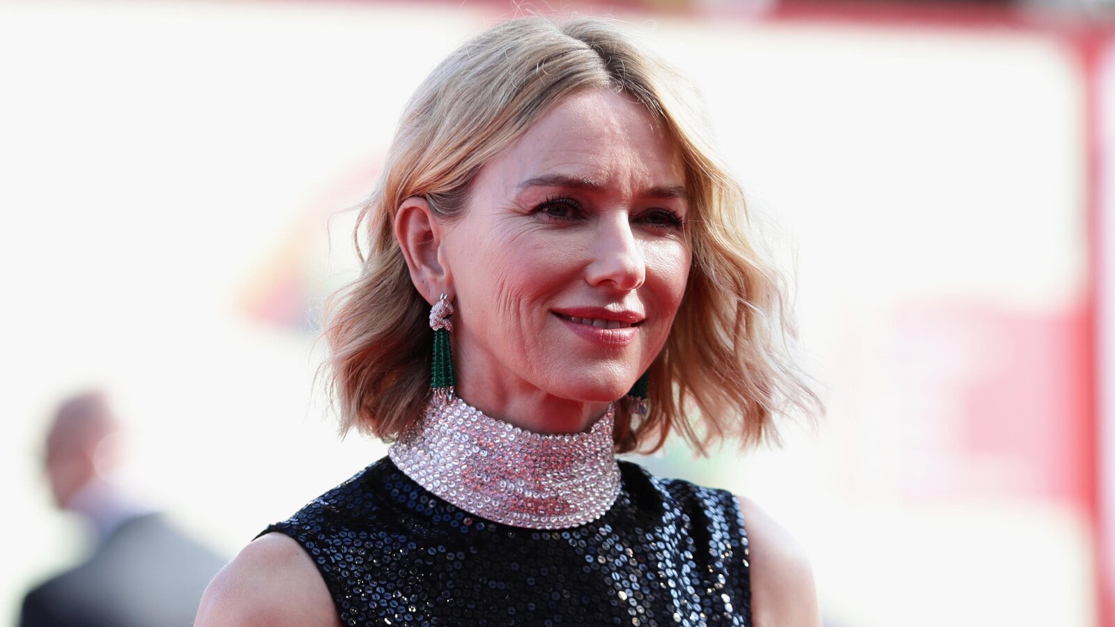 Naomi Watts en tenue de gala, souriante.