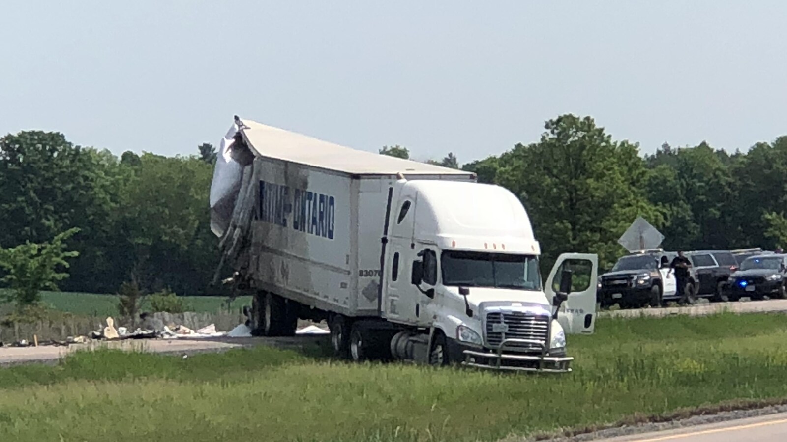Photo d'un camion dans le gazon entre les voies en direction ouest et est de l'autoroute