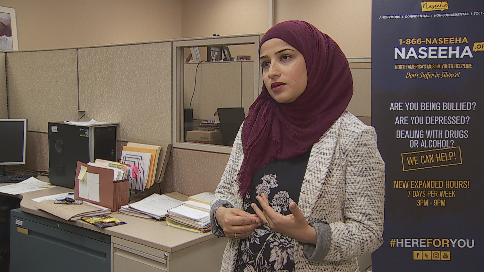 Huma Saeedi se tient devant une pancarte de l'organisme Naseeha.