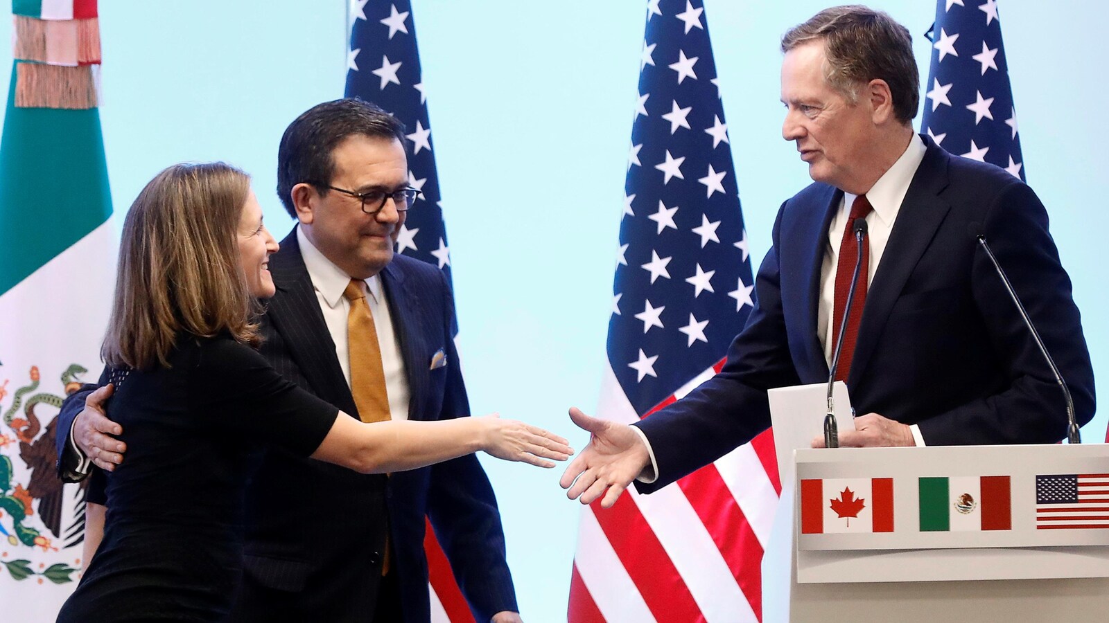 La ministre canadienne des Affaires étrangères Chrystia Freeland, en compagnie du ministre de l'Économie mexicain Ildefonso Guajardo, serre la main du représentant américain au Commerce Robert Lighthizer.