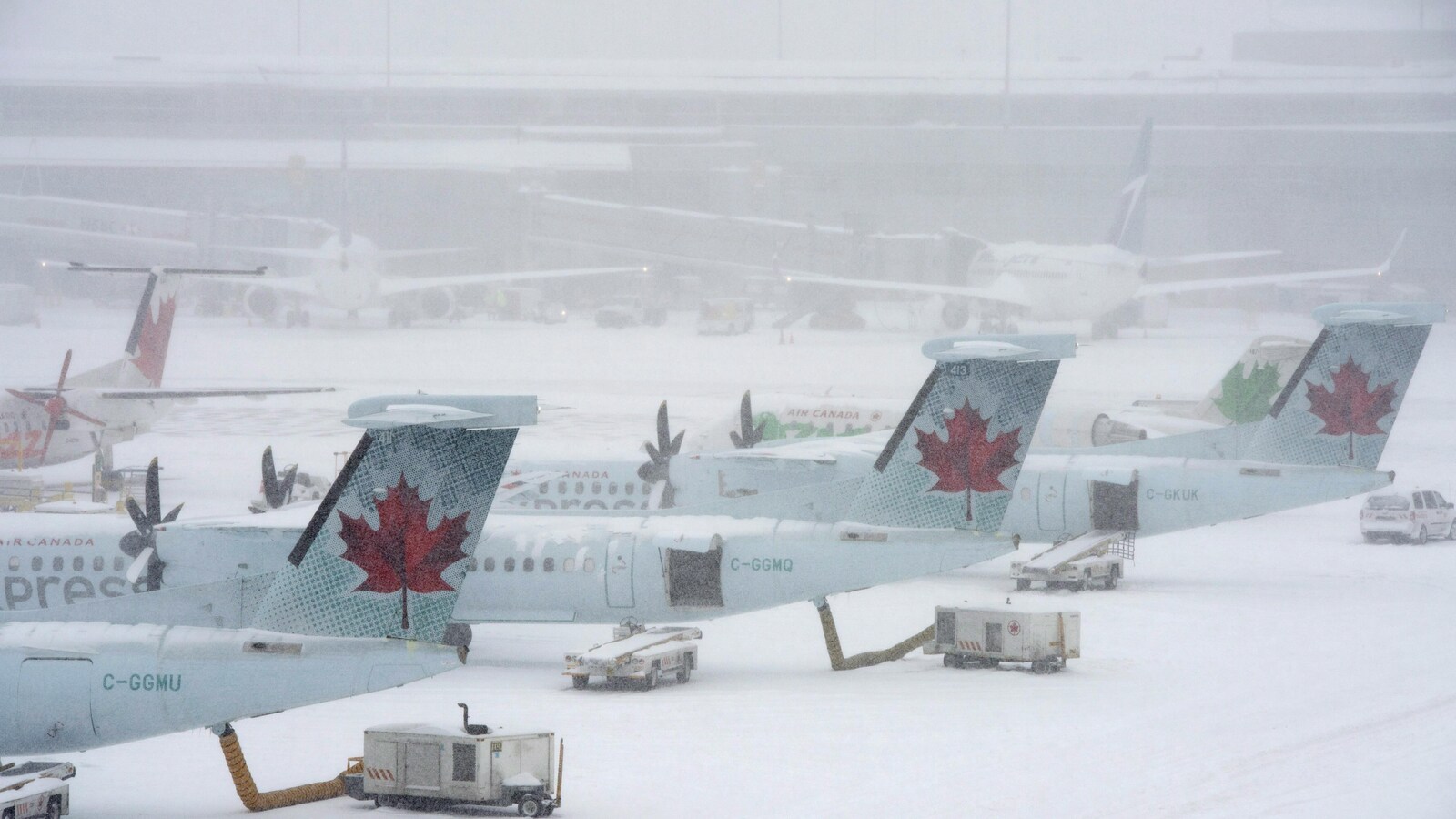 Photo d'avions au sol sous la neige à l'aéroport Pearson de Toronto