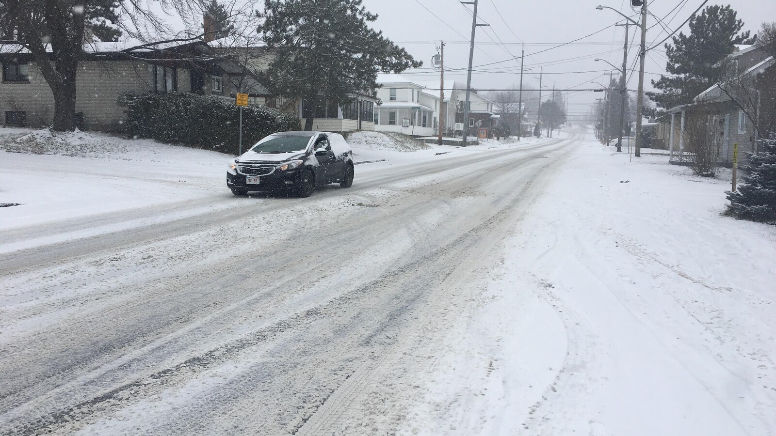 Une voiture qui roule sur une chaussée enneigée à Edmundston.