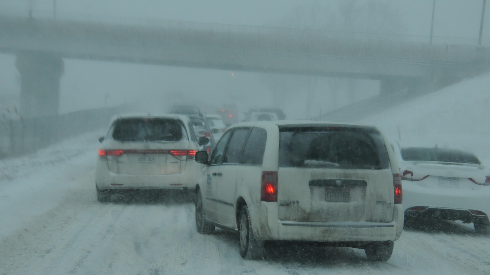 Des véhicules se déplacent sur la voie de service de l'autoroute 15 durant une tempête de neige, sur la Rive-Nord, à Montréal.