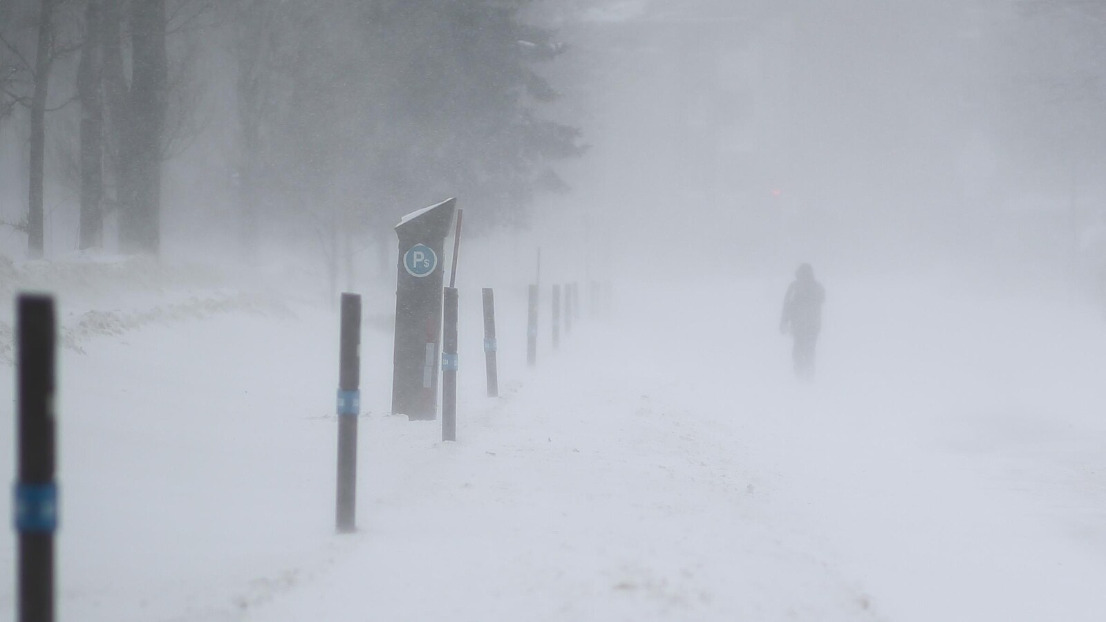 Un piéton sur un trottoir enneigé à Québec.