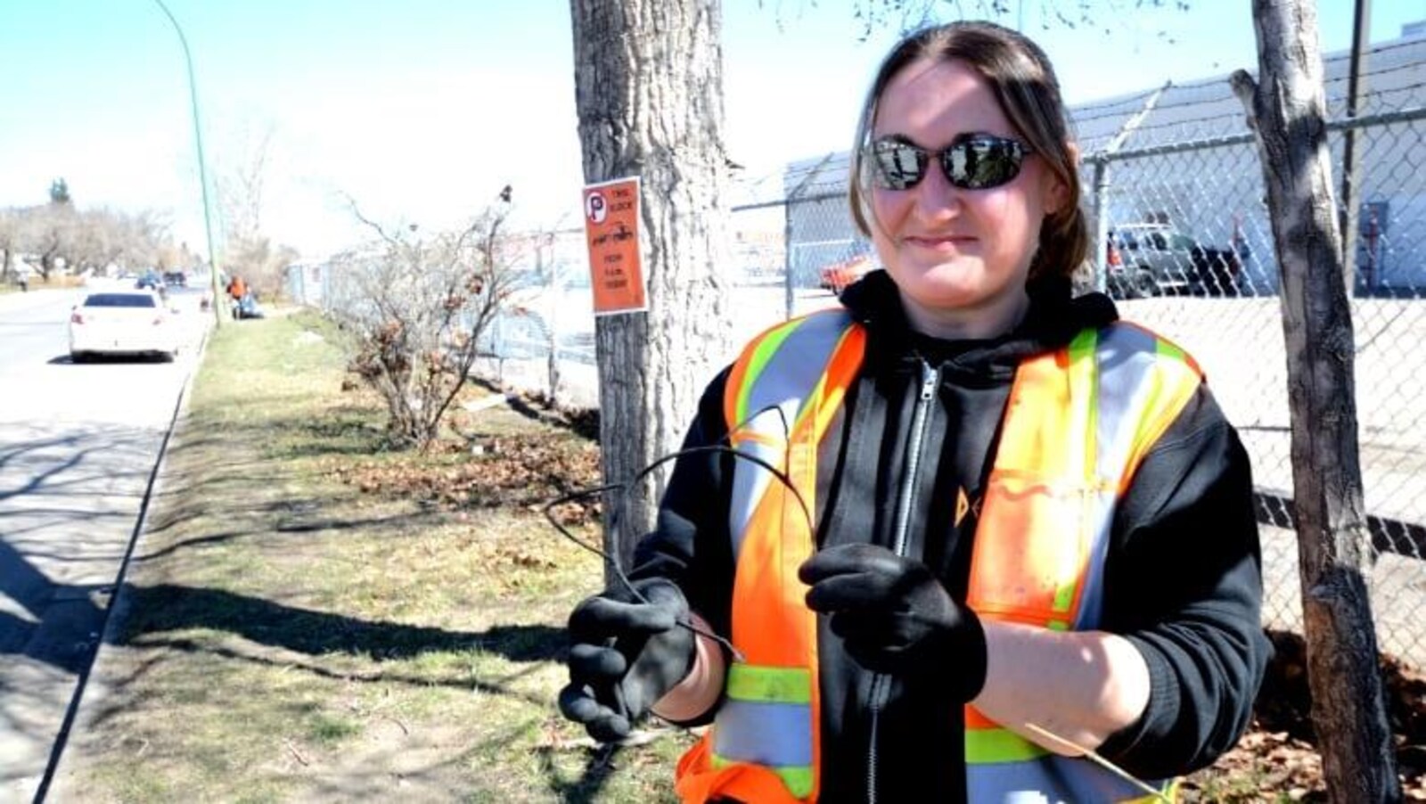 Jackie Tanner porte un gilet orange, des gants et des lunettes de soleil.