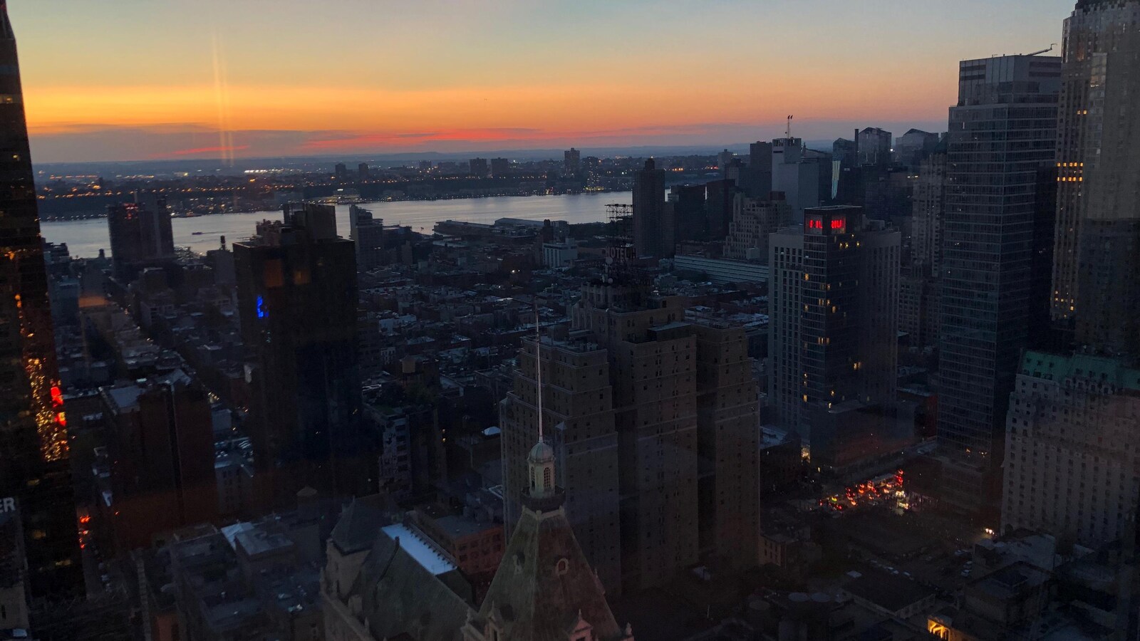 Une vue de la ville à partir d'un gratte-ciel. On voit peu de lumières allumées
