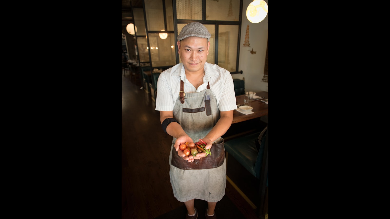 Un homme avec une casquette grise tient des légumes frais
