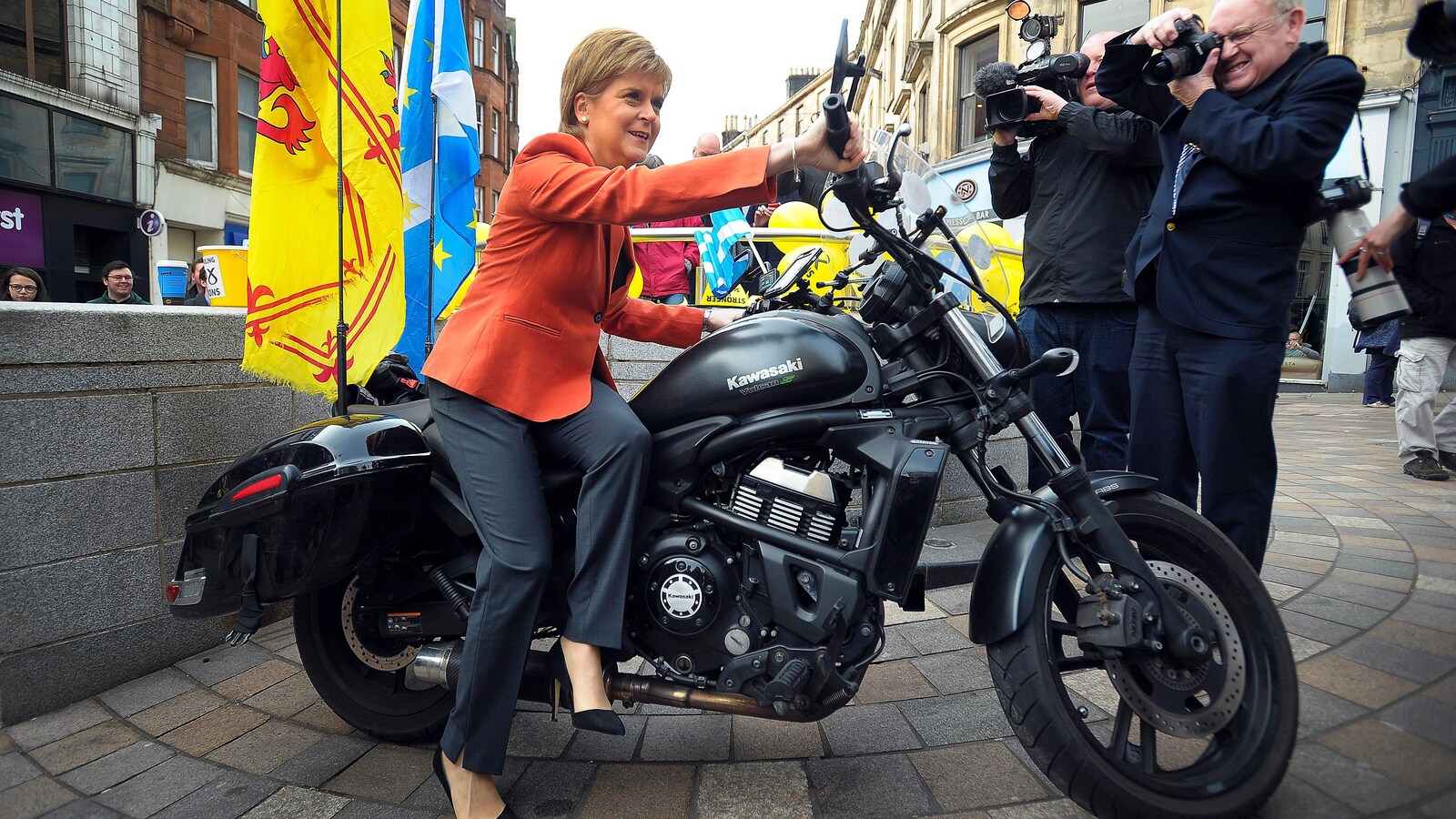 La première ministre écossaise Nicola Sturgeon, sur une motocyclette décorée avec la bannière royale écossaise et le drapeau écossais, est prise en photo.