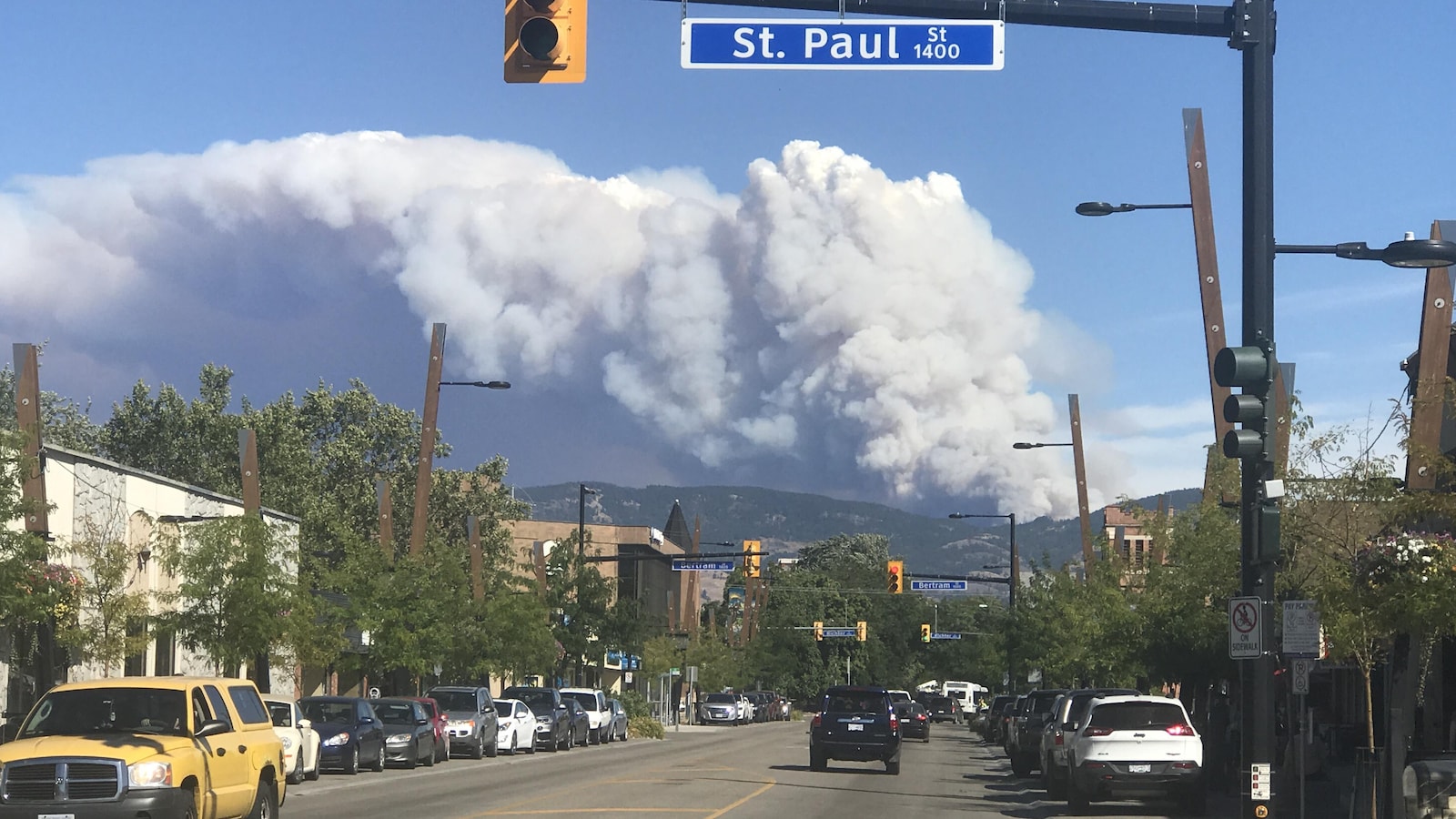 Un panache de fumée s'échappe des montagnes au-dessus d'une rue de Kelowna.