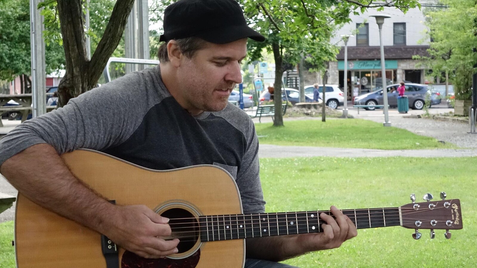 Le musicien Olivier Brousseau chante une chanson avec sa guitare